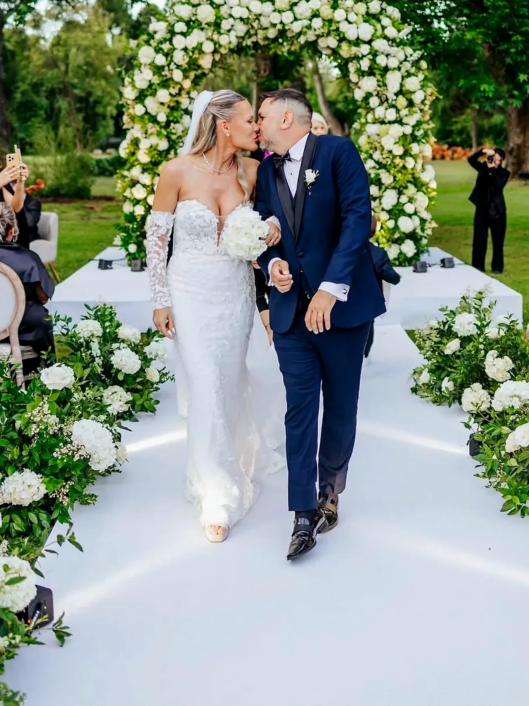 Los novios caminan tomados de la mano por la alfombra blanca, recién casados
