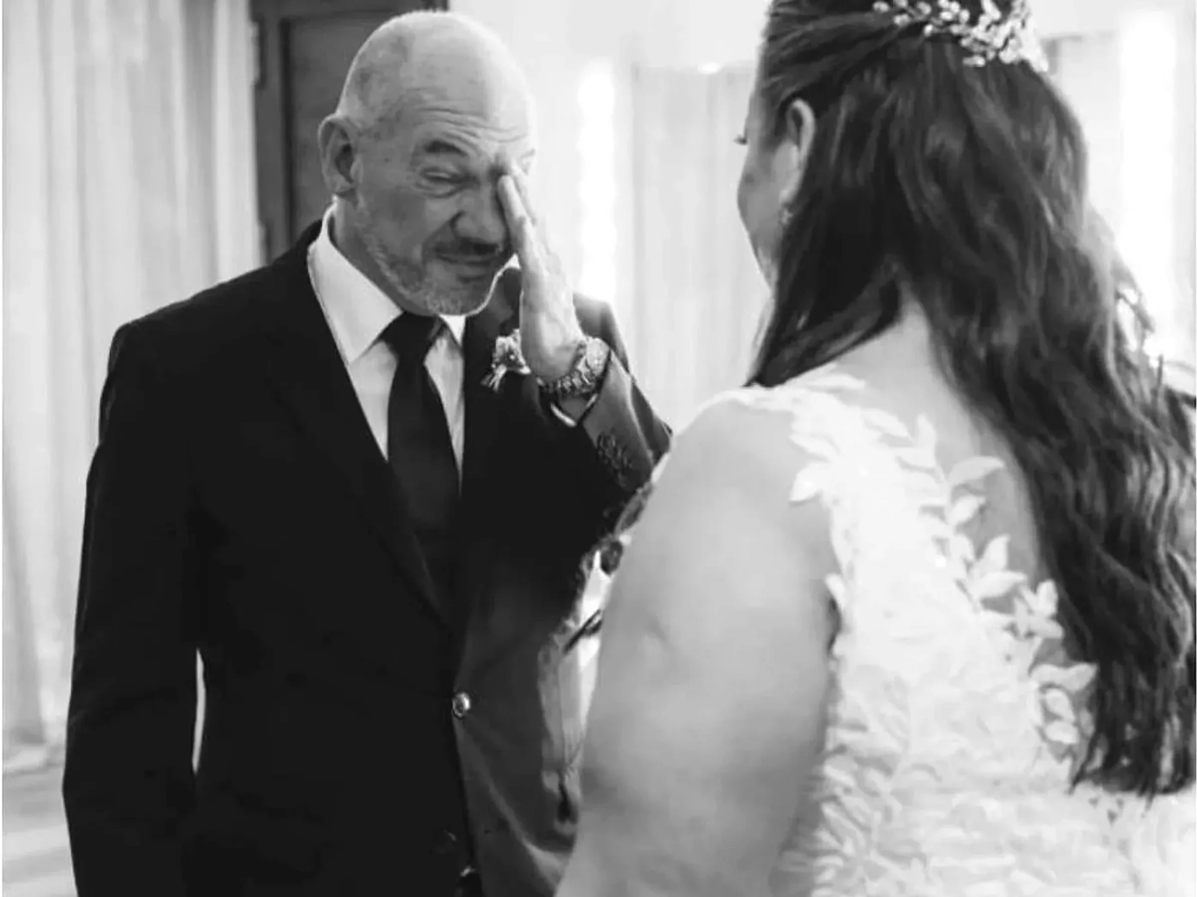 Un padre emocionado sostiene el rostro de su hija antes de la ceremonia