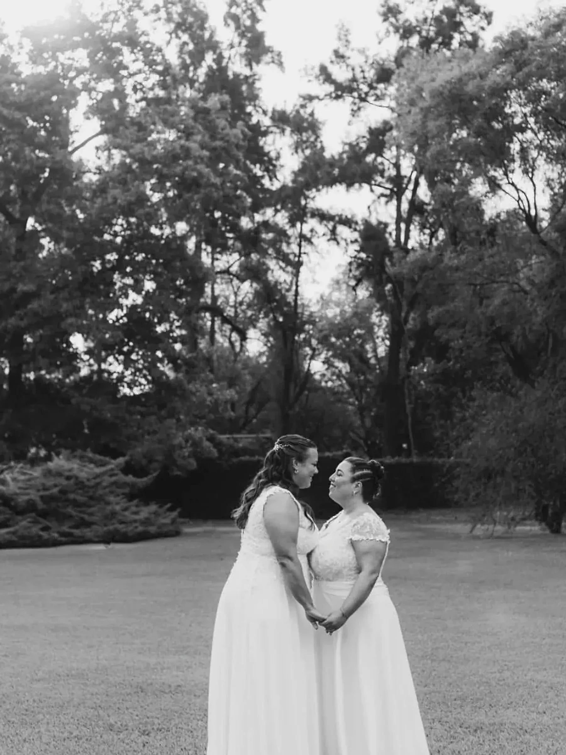 Dos novias abrazadas en el jardín de Rincón, el día de su casamiento