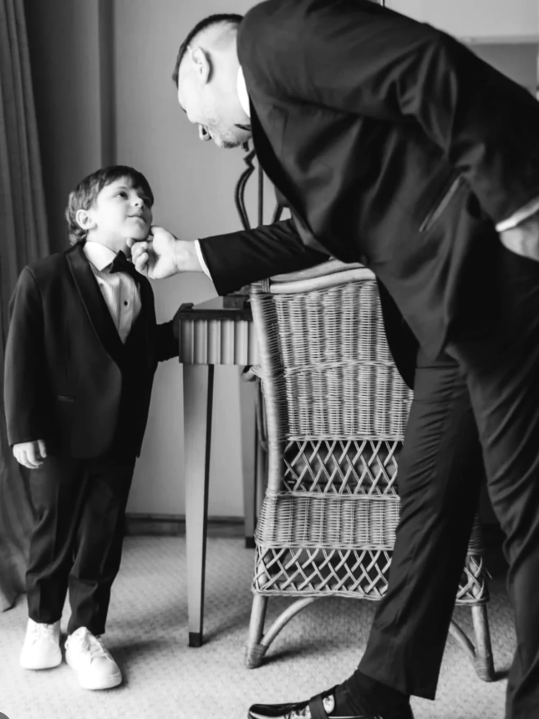 Un padre le ajusta la corbata a su hijo antes de la ceremonia, en Rincón